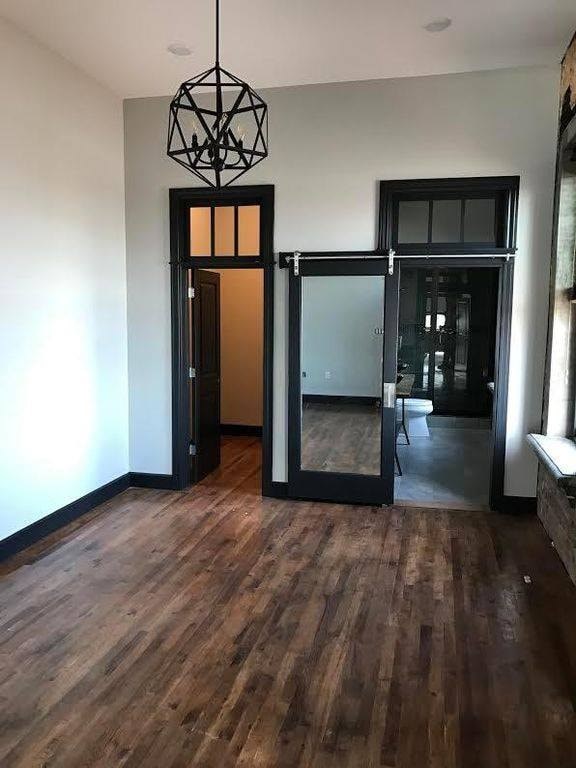 A room with a wooden floor and a black door.