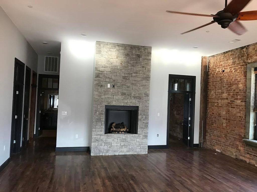 A room with a fireplace and a ceiling fan.
