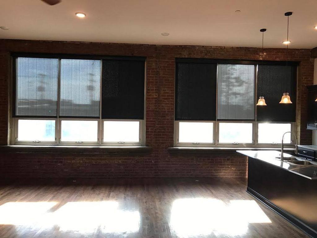 A kitchen with a large window and a wooden floor.