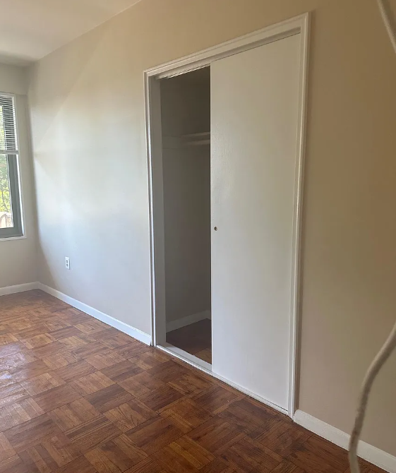 A room with a wooden floor and a white door.