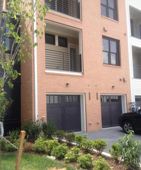 A red brick building with two garage doors.