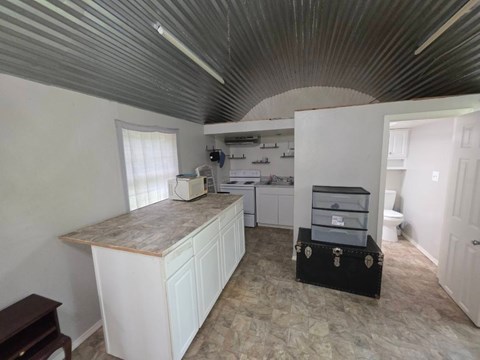 A kitchen with white cabinets and a marble countertop.