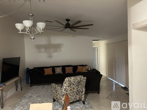 A living room with a black couch and a leopard print chair.