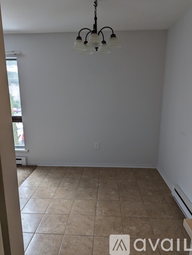 A room with a tiled floor and a chandelier hanging from the ceiling.