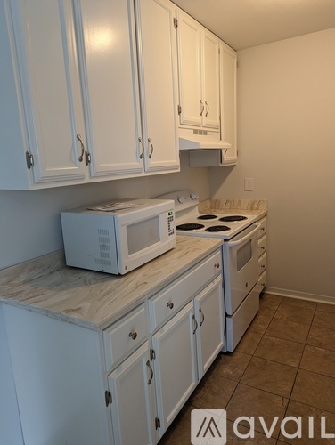 A kitchen with white cabinets and appliances.