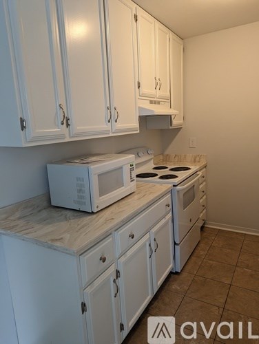 A kitchen with white cabinets and appliances.