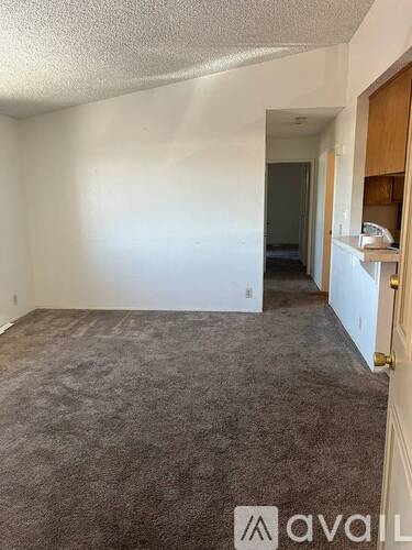 A carpeted room with a door on the right and a wall on the left.