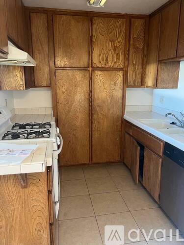 A kitchen with wooden cabinets and a white stove top.