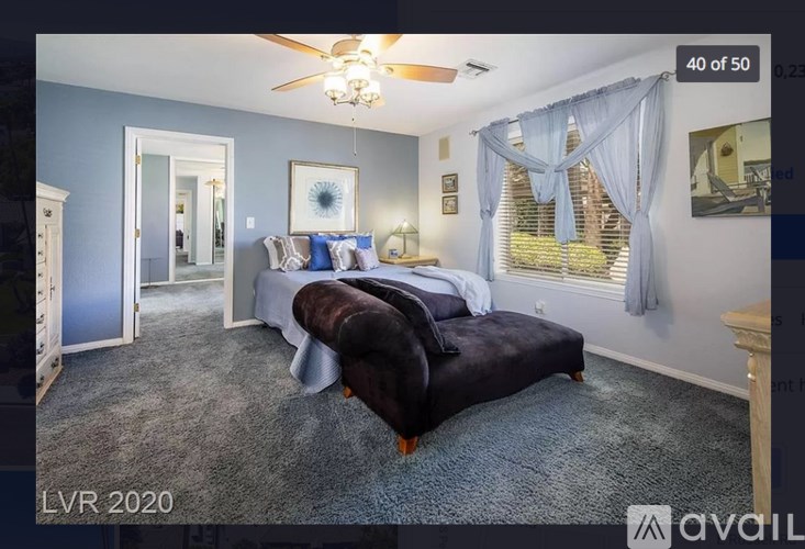 A bedroom with a large bed and a ceiling fan.