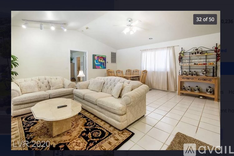 A living room with a white sofa, a coffee table, and a rug.