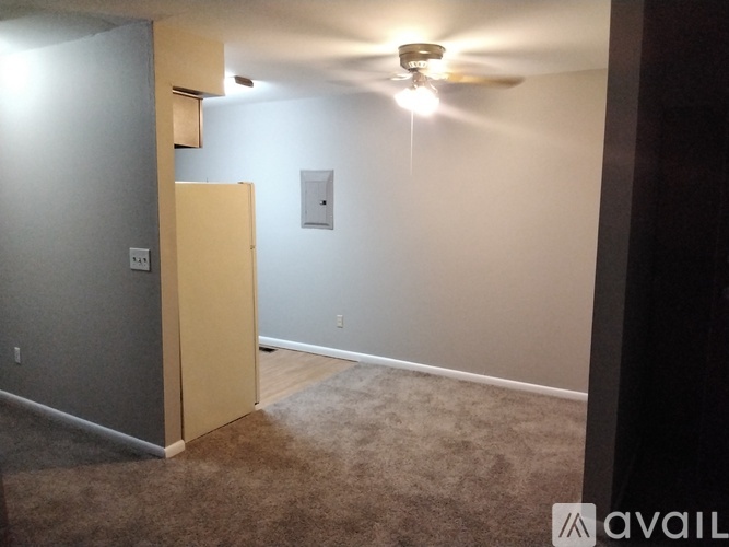 A room with a ceiling fan and a light switch.