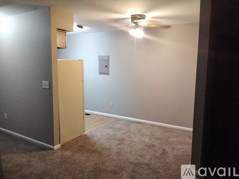 A room with a ceiling fan and a light switch.