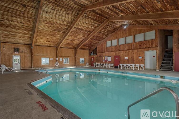 A large indoor swimming pool with a wooden ceiling and walls.