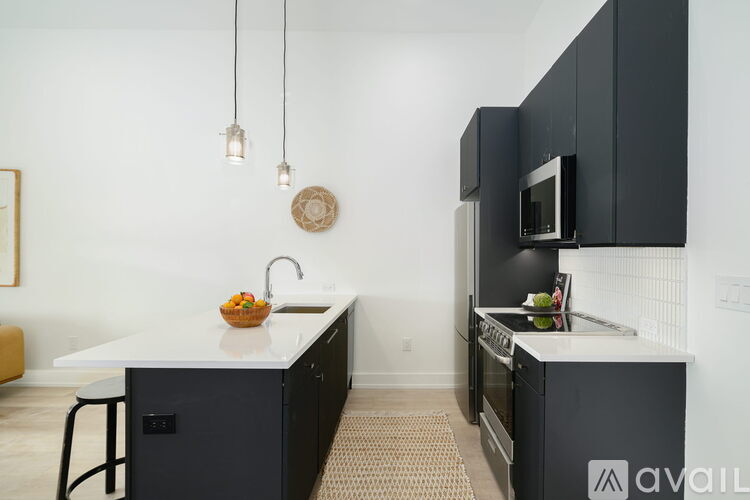 A kitchen with black cabinets and a white countertop.