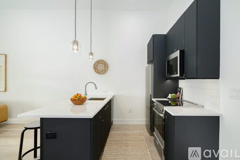 A kitchen with black cabinets and a white countertop.