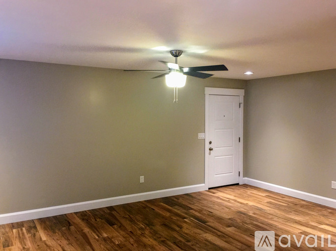 A room with a white door and a ceiling fan.