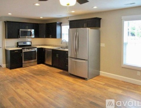 A kitchen with black cabinets and stainless steel appliances.