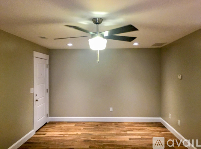 A room with a ceiling fan and a light fixture.