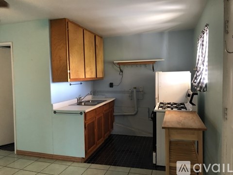 A kitchen with wooden cabinets and a white stove.