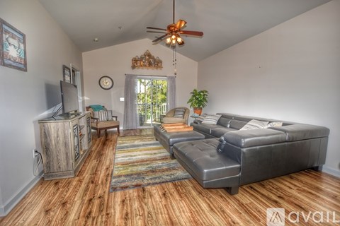 A living room with a grey couch and wooden floors.