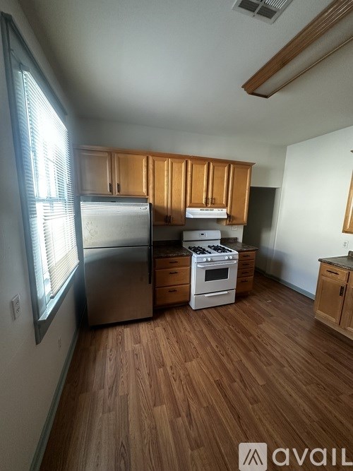 A kitchen with wooden cabinets and a stainless steel refrigerator.