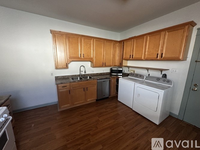 A kitchen with wooden cabinets and a white dishwasher.