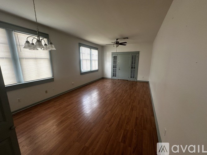 A room with wooden floors and a ceiling fan.