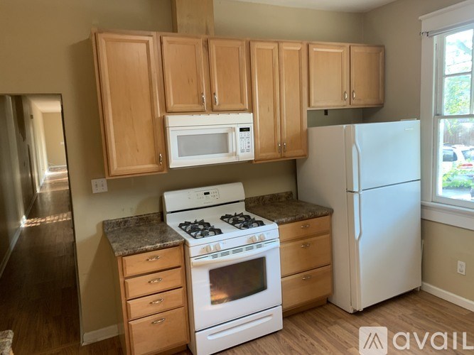 A kitchen with wooden cabinets and white appliances.