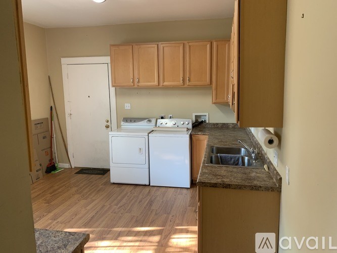 A kitchen with white appliances and wooden cabinets.
