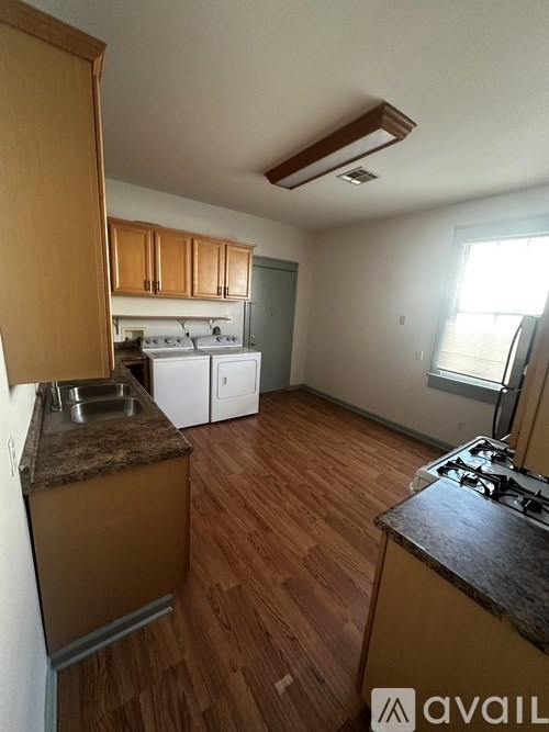 A kitchen with wooden floors and a stove top oven.