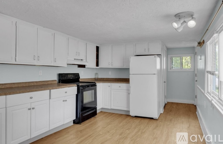 A kitchen with white cabinets and a black stove top oven.