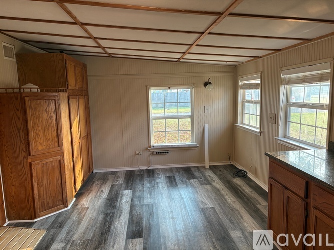 A room with wooden floors and a window with a view of the outside.