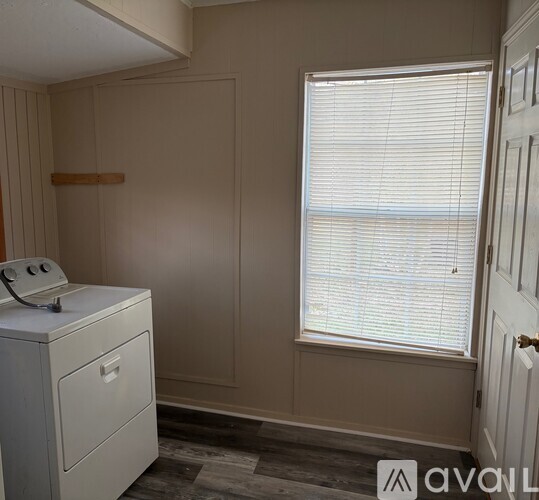 A room with a white telephone on a desk and a window with blinds.