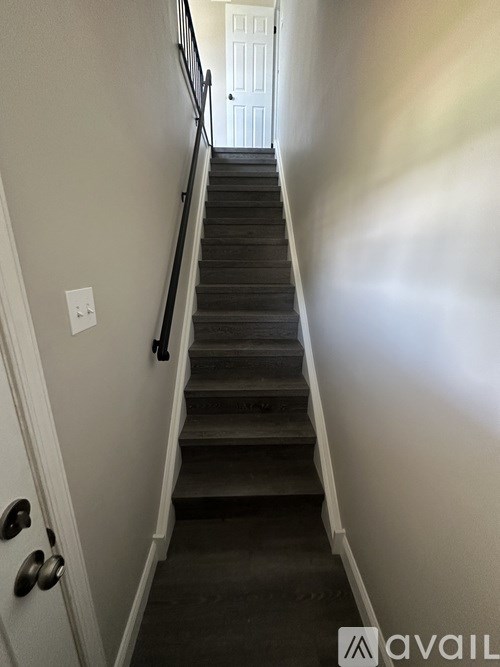 A staircase with a white door at the top.