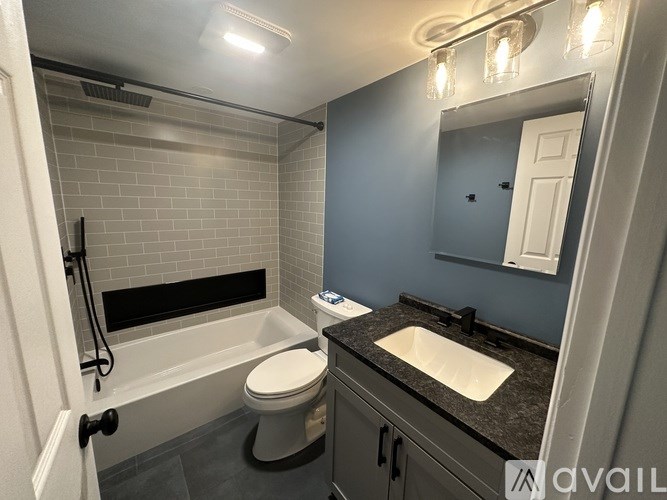 A bathroom with a toilet, sink, and a shower.