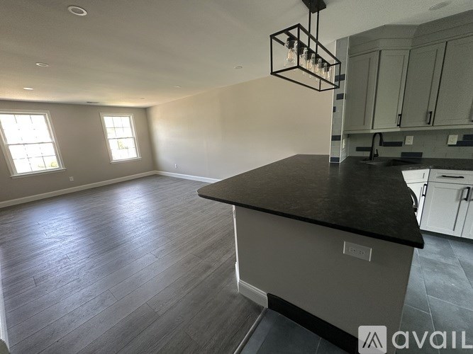A kitchen with a black countertop and white appliances is available for rent.
