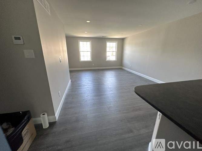 A spacious room with a black countertop and grey flooring.