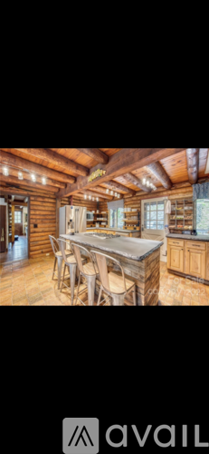 A wooden cabin with a table and chairs in the middle.