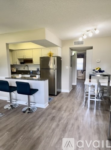 A kitchen with a bar stool and a refrigerator.