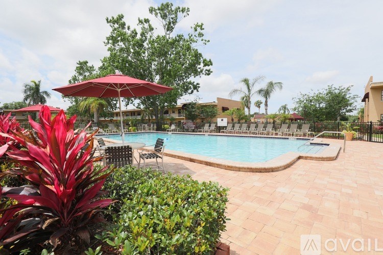 A pool surrounded by green plants and trees.