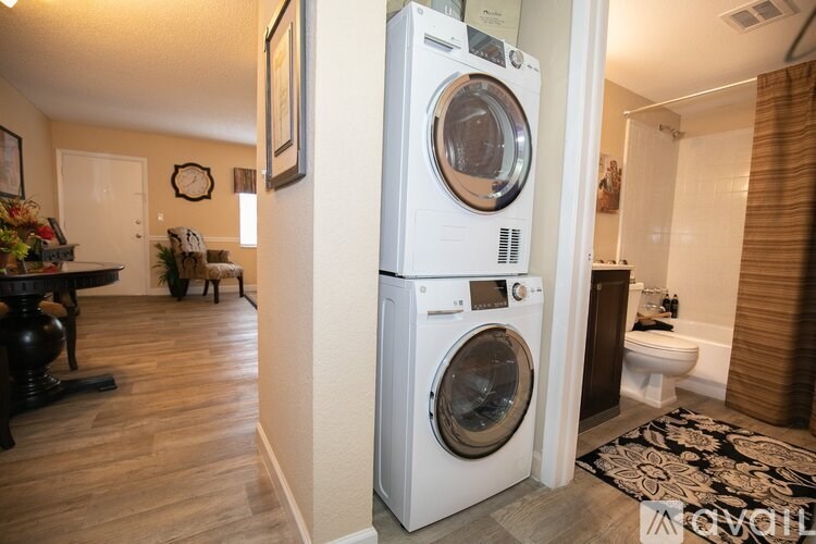 A white front loading washing machine in a home laundry room.