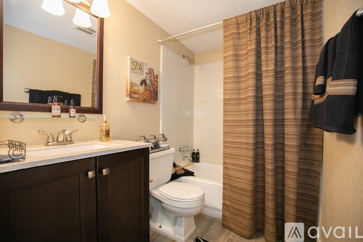 A bathroom with brown cabinets and a white toilet.