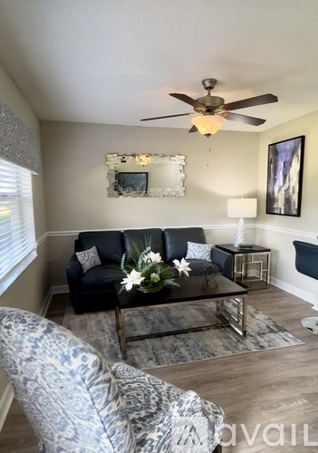 A living room with a black couch and a coffee table.