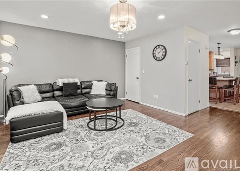 A living room with a grey sofa and a round table.