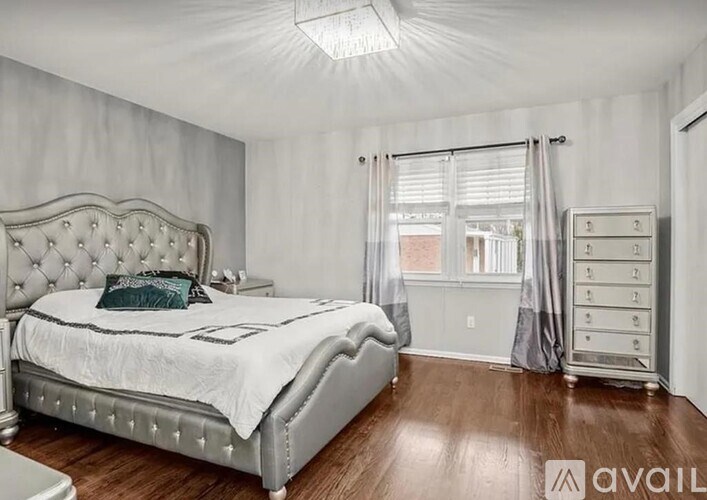 A bedroom with a large bed and a wooden floor.