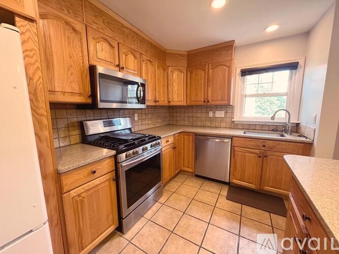 A kitchen with wooden cabinets and a white refrigerator.