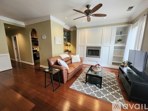 A living room with a brown leather couch and a black coffee table.