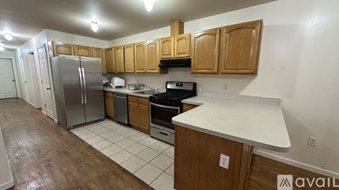 A kitchen with wooden cabinets and a stainless steel refrigerator.