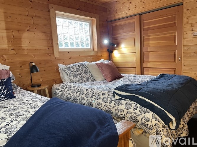 A bedroom with two beds and a window.