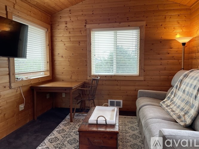 A cozy living room with a couch, chair, and television.